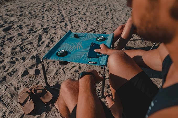 Neso Beach Table - Lightweight, Portable and Foldable Table for Beach, Camping and Outdoor Adventures - Stable Surface - with Cup Holder for Drinks and Phone Pockets - Aqua Fronds