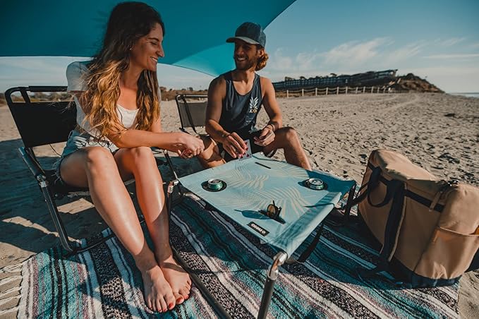 Neso Beach Table - Lightweight, Portable and Foldable Table for Beach, Camping and Outdoor Adventures - Stable Surface - with Cup Holder for Drinks and Phone Pockets - Aqua Fronds